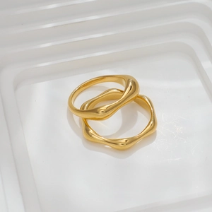 Minimalist irregular wave texture titanium steel rings with 18k gold plating on white stand