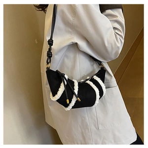 Detail of plush拼接 crescent bag with knot rope strap and golden metal hardware
