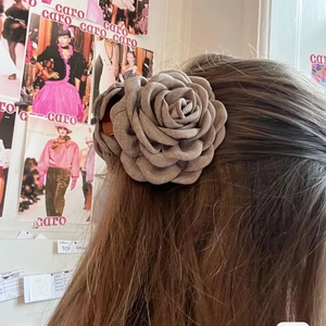 Macro detail of large mocha fabric camellia hair claw clip shown on styled hair