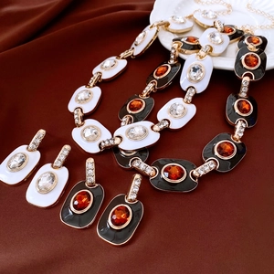 Détails d'une parure de bijoux vintage en émail avec collier et boucles d'oreilles ovales
