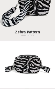 Detail showing zebra pattern crossbody bag with wide shoulder strap and silver hardware