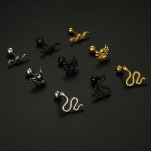 Macro detail of punk spider and snake stud earrings in silver, gold and black finish