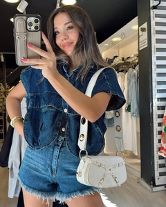 Détail du gilet en jean bleu foncé avec col montant et short en jean effiloché assorti