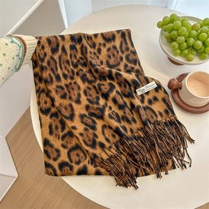 Classic leopard print cashmere scarf with fringe, folded on a white table background
