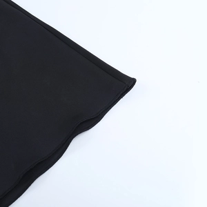 Primer plano detallado del dobladillo del vestido negro mostrando costuras y textura
