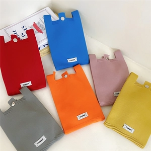 Flat lay of knit phone bags in six vibrant colors with silver metal snap buttons
