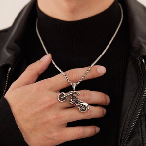 Collier pour homme avec pendentif moto rétro argenté sur une veste en cuir noir
