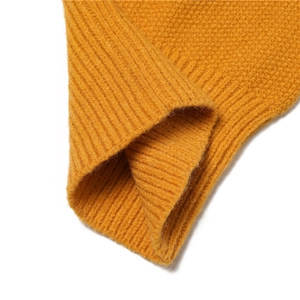Close-up of yellow waffle knit fabric with ribbed cuffs on a winter warm knitted hat