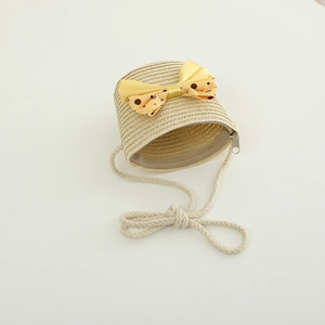 Close-up of kids woven straw crossbody bag featuring a yellow polka dot satin bow detail