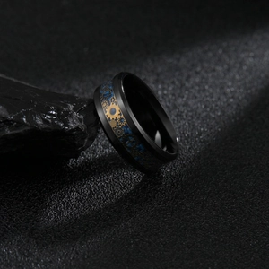 Détail macro d'une bague steampunk 8mm noire avec engrenages bleus et or incrustés