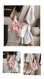 Detail of a creamy white leather bag featuring a large pink bow and chain strap