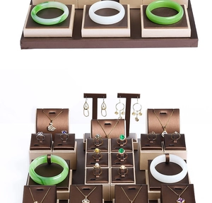 Macro shot of dark brown and beige leather jewelry display stands for rings and necklaces