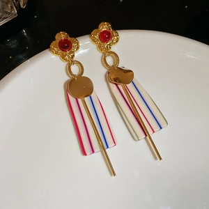 Detail of vintage flower earrings with red gems and striped rectangle pendants