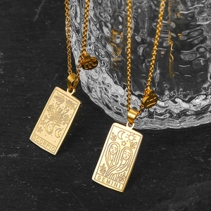 Close-up of Scorpio and Gemini tarot card pendants on gold stainless steel chains