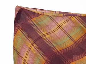Détail de la texture du tissu à carreaux rouge et violet avec coutures fines et tissage