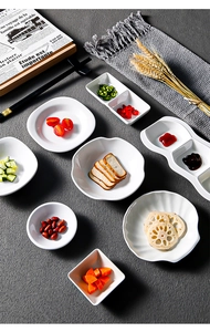 Overhead view of various white melamine dipping sauce dishes in different shapes and compartments