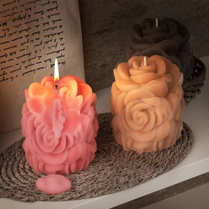 Detailed view of rose bouquet scented candles with realistic petal textures and lit wick