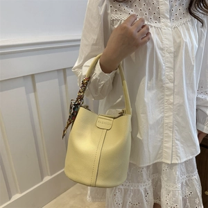 Chic beige lychee leather bucket bag with decorative floral scarf handle detail