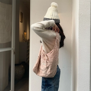Detailed shot of pink corduroy tote bag with small floral patterns and side pocket