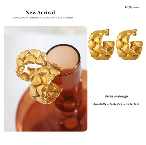 Macro detail of high-polish 18K gold-plated stainless steel heart-shaped hoop earrings