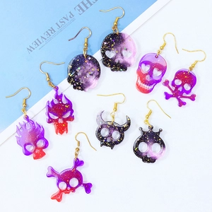 DIY skull resin earring molds with glitter finish in purple and pink gradient design