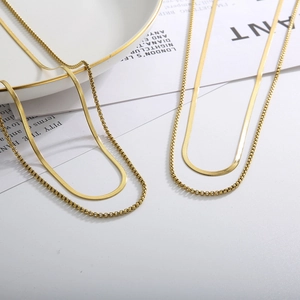 Detail of gold-plated titanium steel layered necklace with snake and box chain textures
