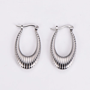 Macro detail of silver geometric U-shaped earrings with textured vertical stripe design