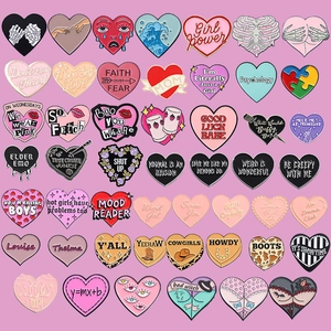 Detailed grid collection of multiple colorful heart-shaped enamel pins with varied slogans
