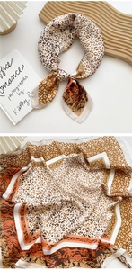 Detailed view of leopard print silk scarf with warm orange and brown tones