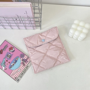 Pink quilted fabric storage pouch with heart detail shown in a lifestyle desk setting