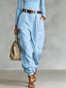 Detail showing high-waist cargo pants with side pockets and a stylish brown belt