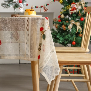 Christmas tablecloth with red embroidery and lace edges on a cozy holiday dining table