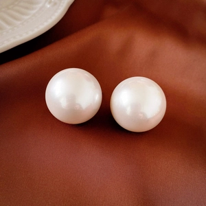 Macro shot of large round white pearls with high luster on a luxury satin background