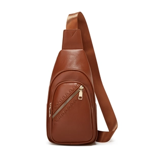 Detail of brown litchi pattern leather sling bag featuring golden metal zippers and strap