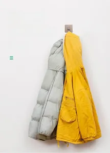 Heavy duty wall hook holding three thick down jackets to show its weight capacity