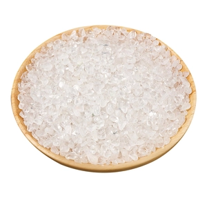 Natural clear white quartz crystals piled in a round wooden bowl on a white background