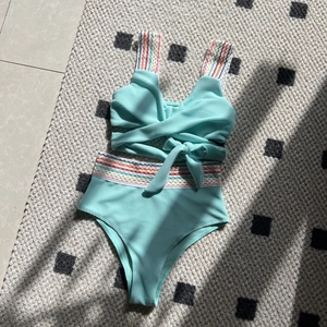 Detail of mint green waffle bikini set featuring vibrant rainbow wavy trim on straps