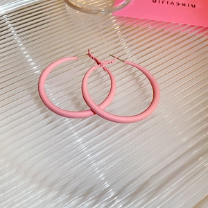 Macro detail of pink matte hoop earrings featuring high-quality acrylic finish and silver posts