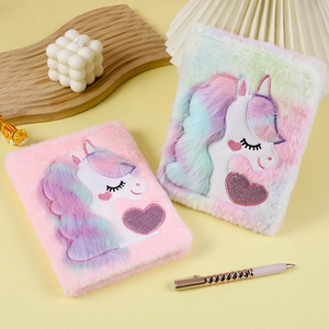 Close-up of fluffy plush unicorn notebooks with colorful embroidery and sequin hearts
