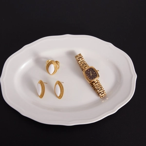 Vue détaillée d'une bague et boucles d'oreilles en or 18 carats avec agate blanche sur plat