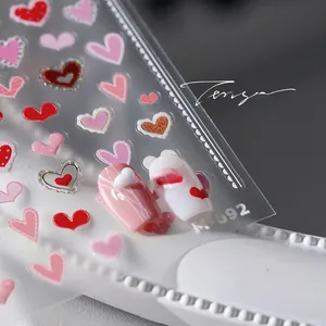 Detailed view of M-692 3D heart nail art stickers applied on pink and white nails