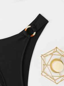 Detail view of black bikini side with amber buckle and high-elastic textured fabric
