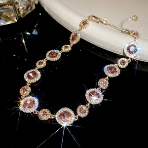 Detailansicht der luxuriösen Goldhalskette mit funkelnden rosa Kristallen und Diamant-Halo