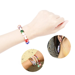 Detail of colorful lampwork mushroom beads and alphabet charms on handmade bracelets