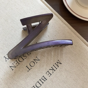 Detail of Z-shaped hair claw clip with purple glitter finish and inner metal spring