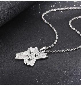 Détail macro du pendentif de collier argenté avec tête de dessin animé et cristaux