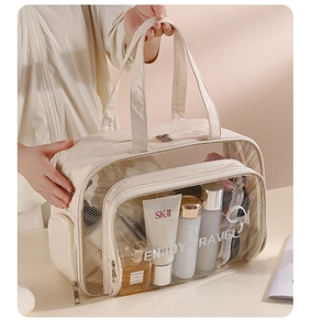 Detail view of beige PU toiletry bag showing ENJOY TRAVEL text and clear PVC window