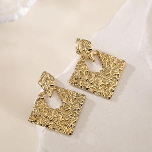 18K gold plated stainless steel geometric earrings with hammered texture on stone display