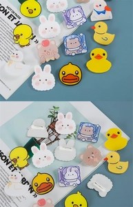 Detail showing acrylic duck pins and back safety pin closure for backpack decoration