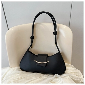 Detail of a black crescent shoulder bag with gold metal buckle and knotted strap accents